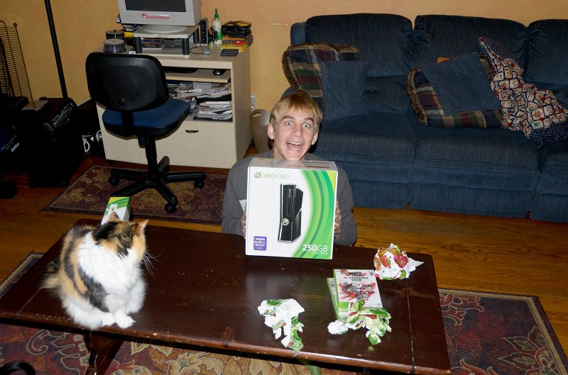 XmasDec11-7537.jpg - Mike, home from school, opens early Christmas present -- Xbox!!