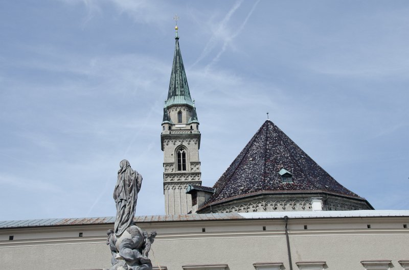 Salzburg051012-0608.jpg - Marienstatue in the center of the Domplatz. Background: the tower of the Franziskanerkirche / Franciscan Church