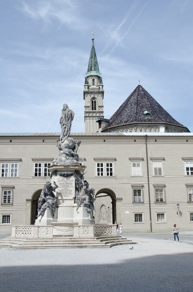 Salzburg051012-0609.jpg - Marienstatue in the center of the Domplatz. Background: the tower of the Franziskanerkirche / Franciscan Church