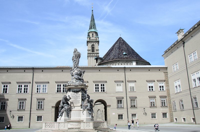 Salzburg051012-0607.jpg - Marienstatue in the center of the Domplatz. Background: the tower of the Franziskanerkirche / Franciscan Church